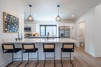 A kitchen with a large island with four chairs